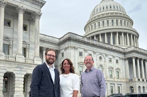 Image of employees in front of the US Capitol building