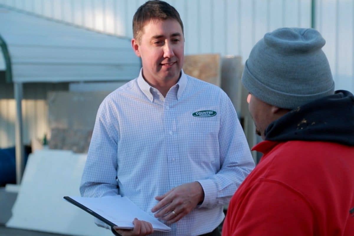 Insurance representative talking with granite worker 