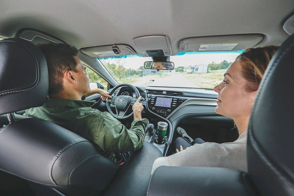 A couple driving home with their new car for the first time