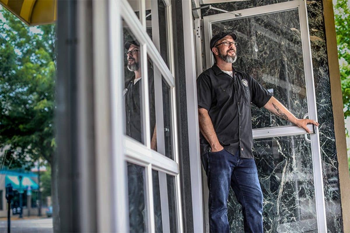 Worker standing in doorway of business