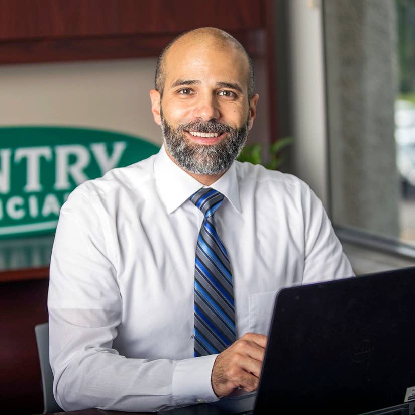 Smiling insurance agent at desk with laptop